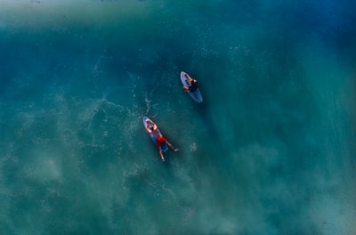 白天蓝色冲浪板上两个人的俯视照片
